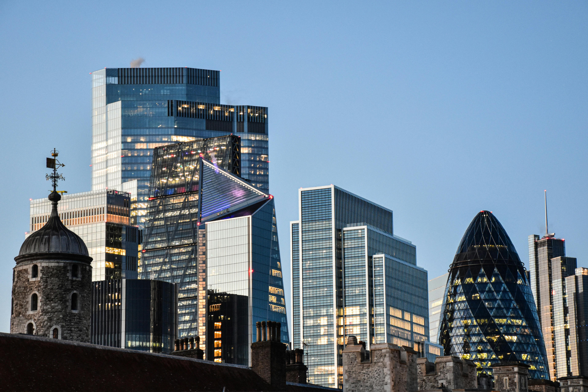 Skyline of modern glass skyscrapers under a clear blue sky.